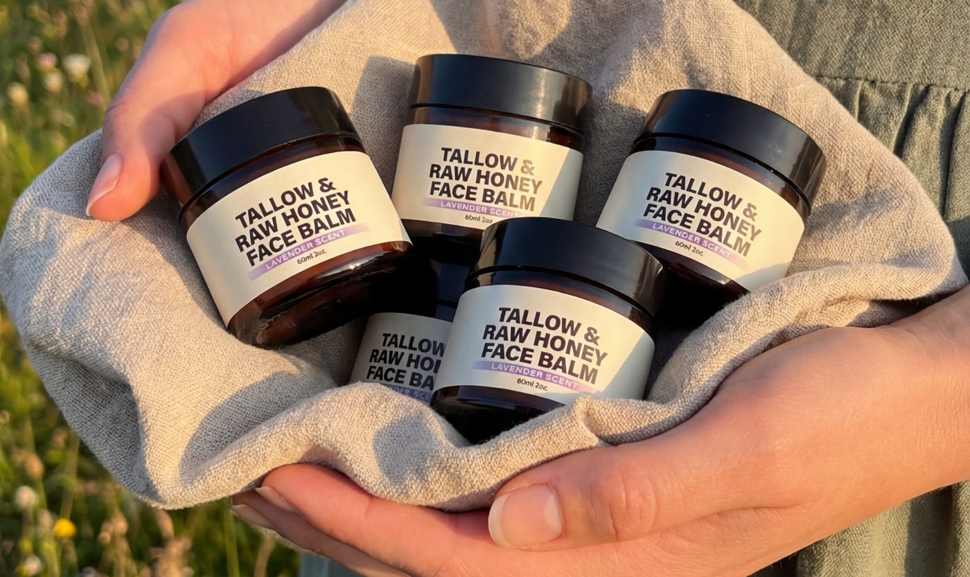 Five face balm jars nestled in a linen cloth in a meadow